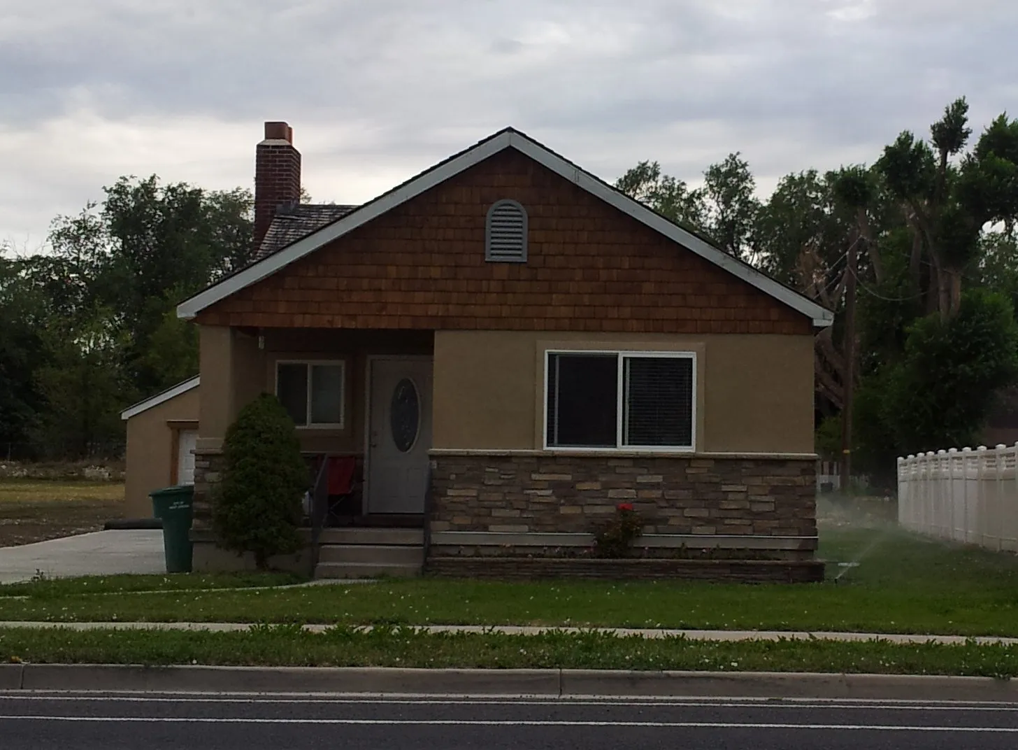 House combining shakes, stucco, brick, and a red brick chimney